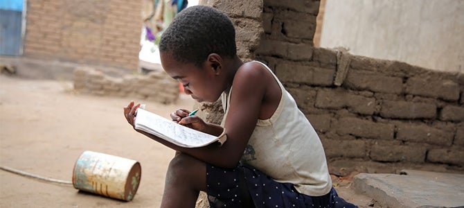Child reading in Malawi A Malawi Child learning from Nu Skin's Educational initiatives